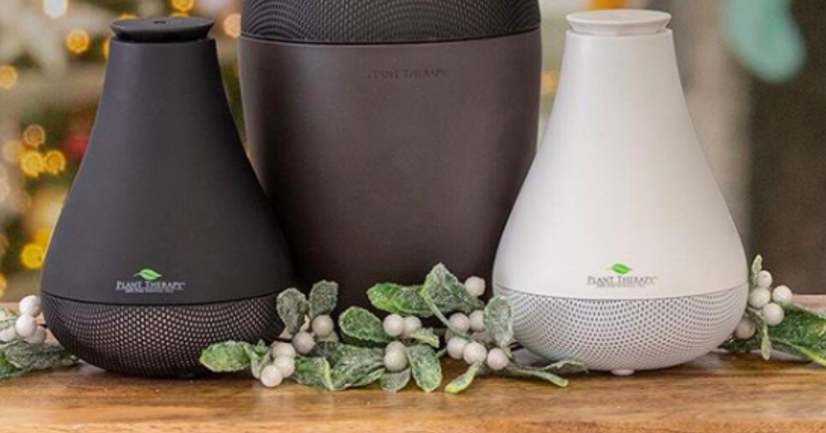 NovaFuse USB Diffuser in black and white displayed on table with leaves and berries