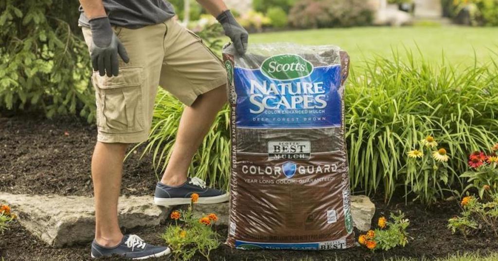 man standing next to a bag of mulch