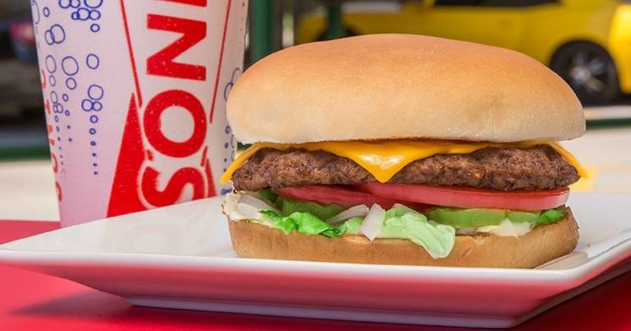 sonic cheeseburger on white plate with sonic cut in the background