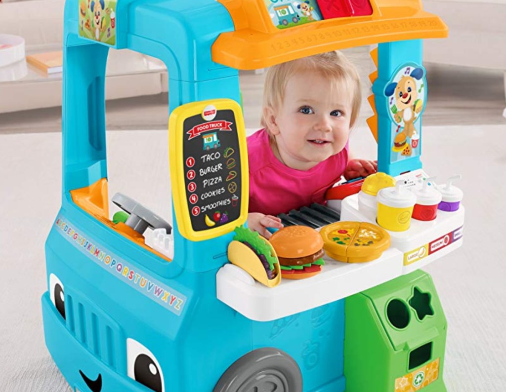 Fisher-Price Laugh and Learn Servin' Up Fun Food Truck with a toddler inside playing