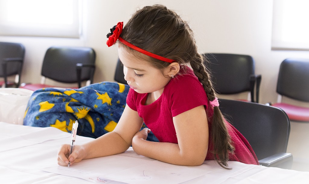 little girl writing on paper
