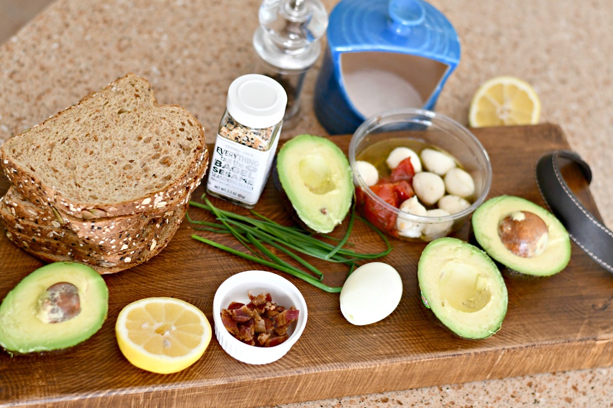 ingredients to make avocado toast recipes on a wood serving board