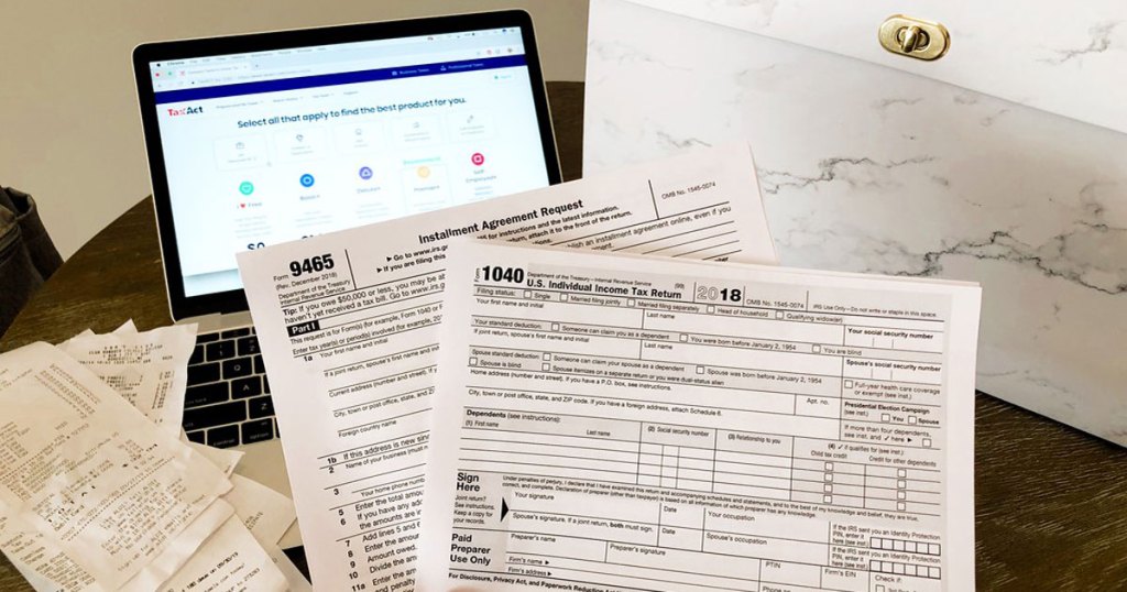 Tax forms shown in front of laptop