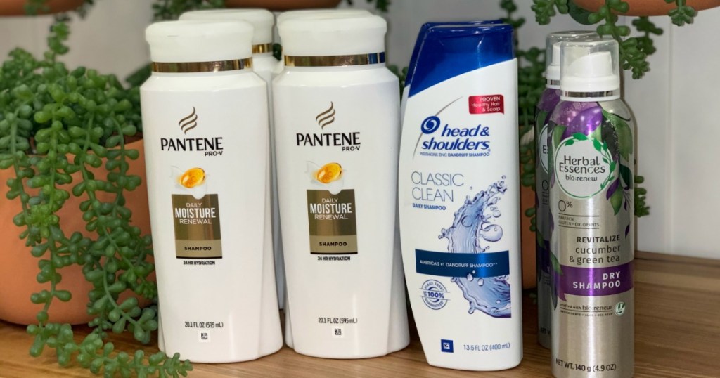 Pantene, Head & Shoulders and Herbal Essences hair care products on a shelf with plants