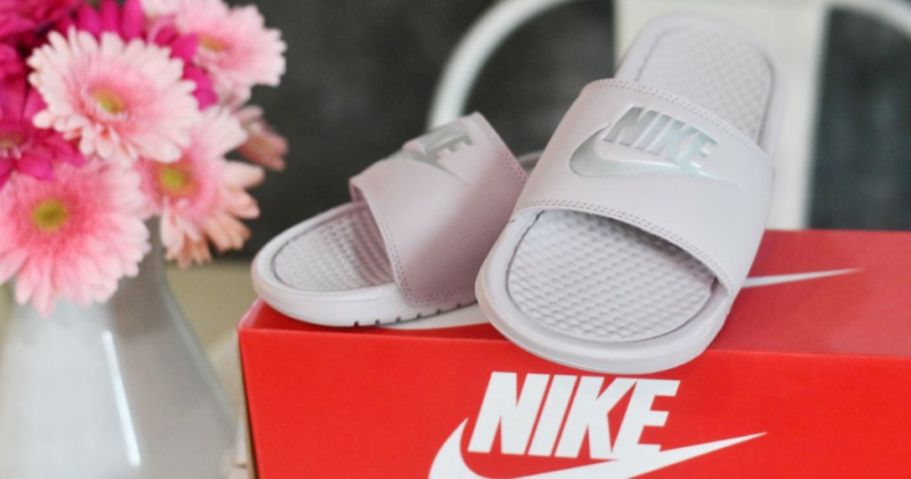 nike slides sitting on red shoebox with flowers