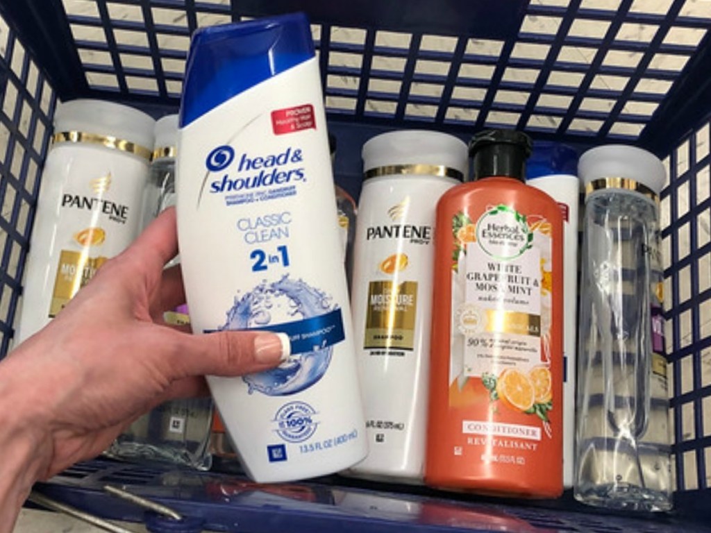 Woman holding Head & Shoulders Shampoo with other P&G hair care products in background