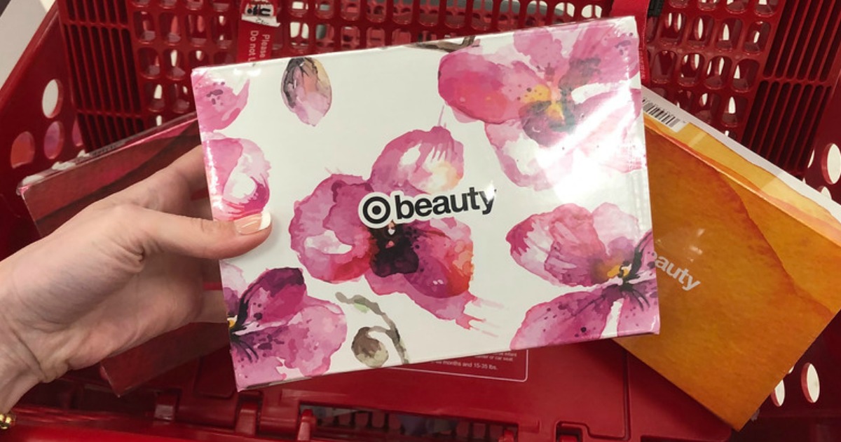 hand holding box with beauty products in front of shopping cart