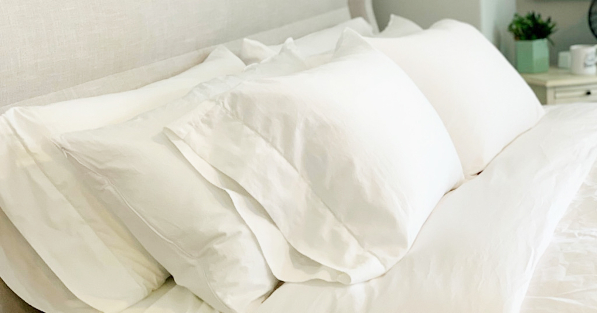 white bedding with three rows of white fluffy pillows