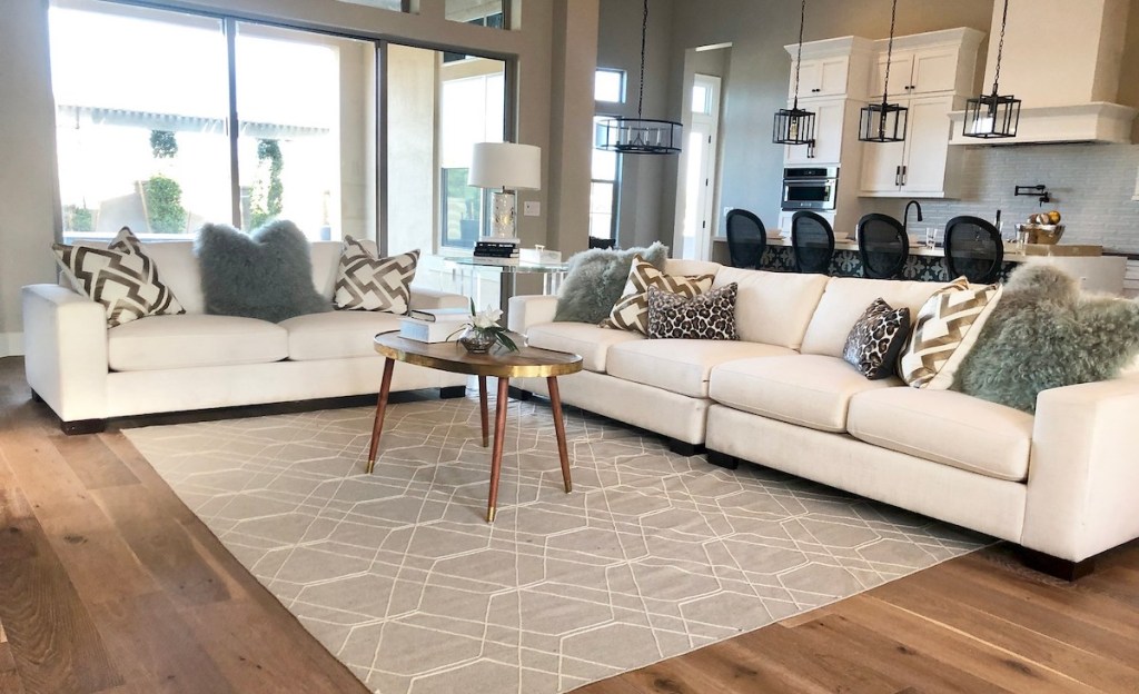 living room with white couches and various sizes and colored pillows