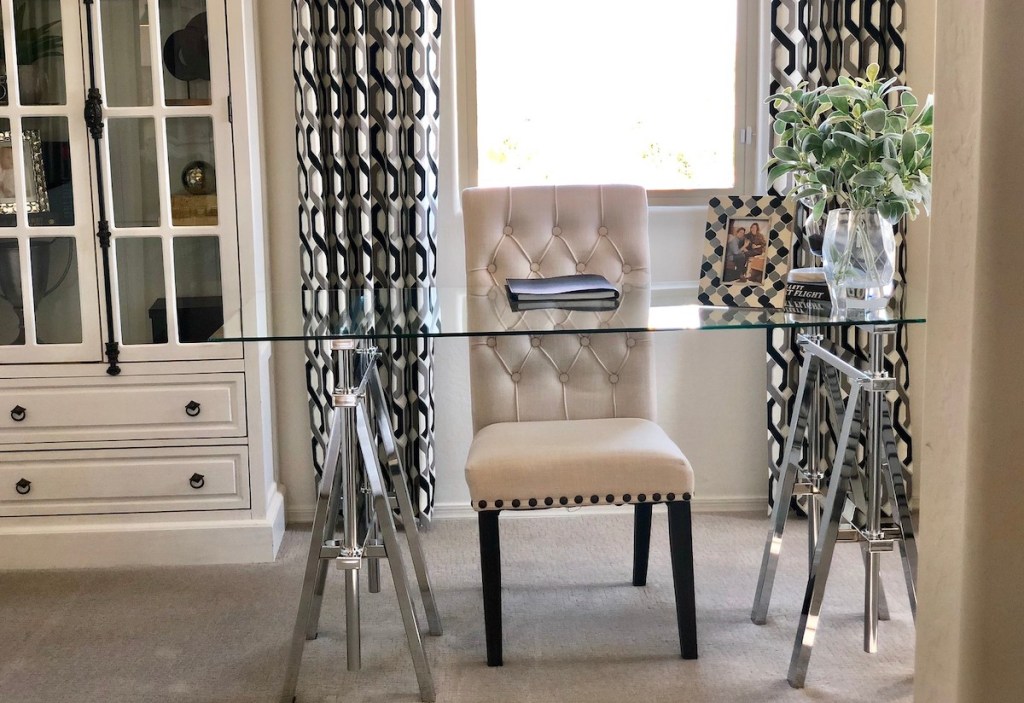 office with tufted chair and clear glass desk