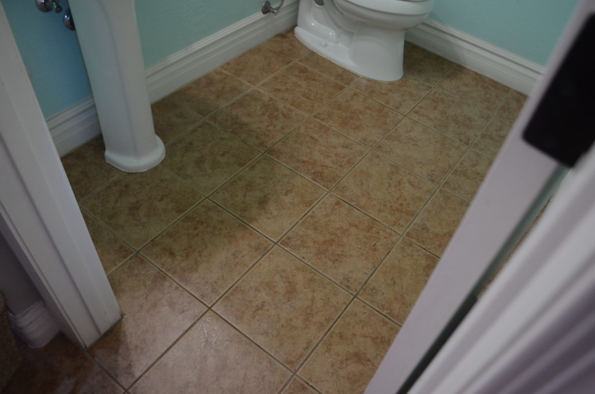 bathroom tile floor with dirty grout