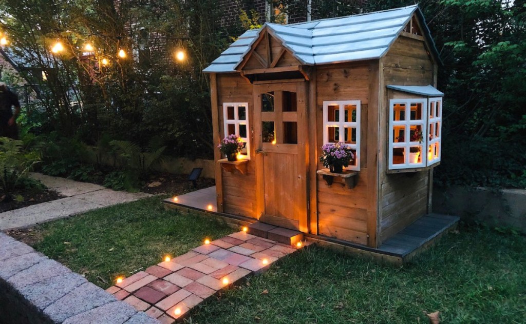 kids wooden playhouse with string lights and pathways - selling your home