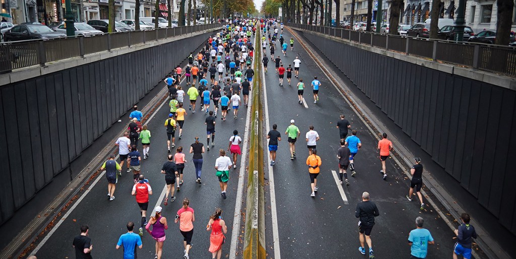 large group of people running on highway in organized race