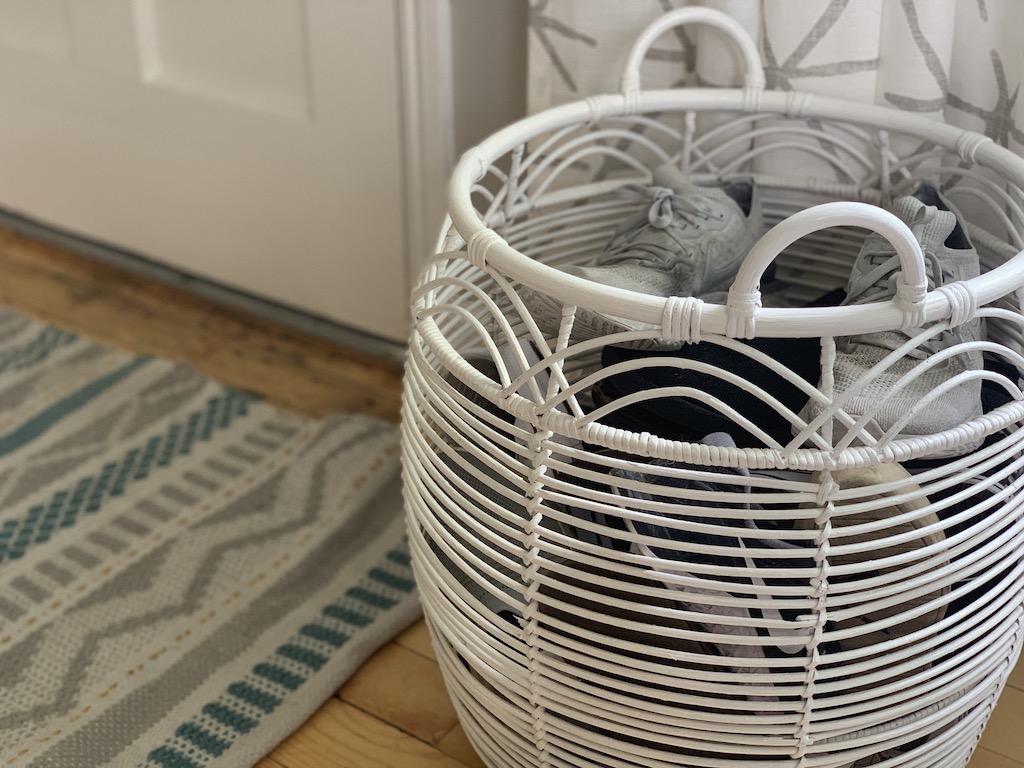 large white basket with shoes by front door 