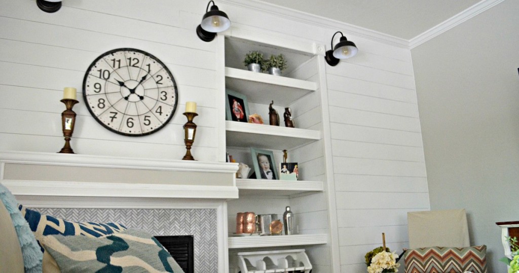 white shiplap wall with fireplace and white mantel with various home decor