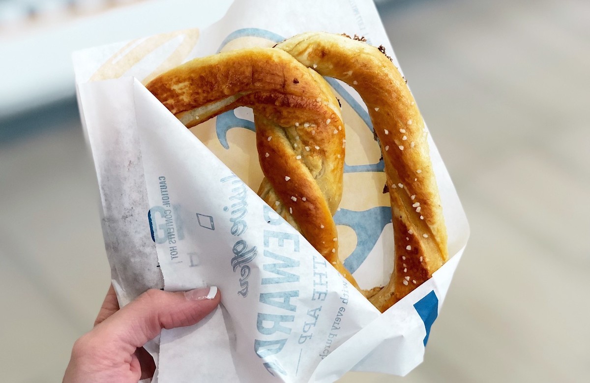 woman holding a bag with soft salted pretzel inside since she got free food when you sign up for Annie's app.