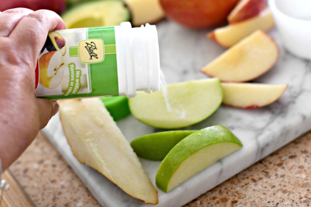 sprinkling ball fruit-fresh onto an apple slice