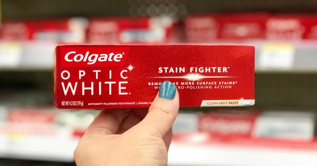 hand holding colgate optic white toothpaste at walgreens