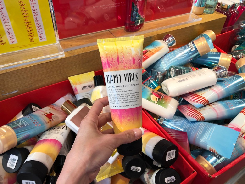 hand holding Happy Vibes Bath & Body Works body cream