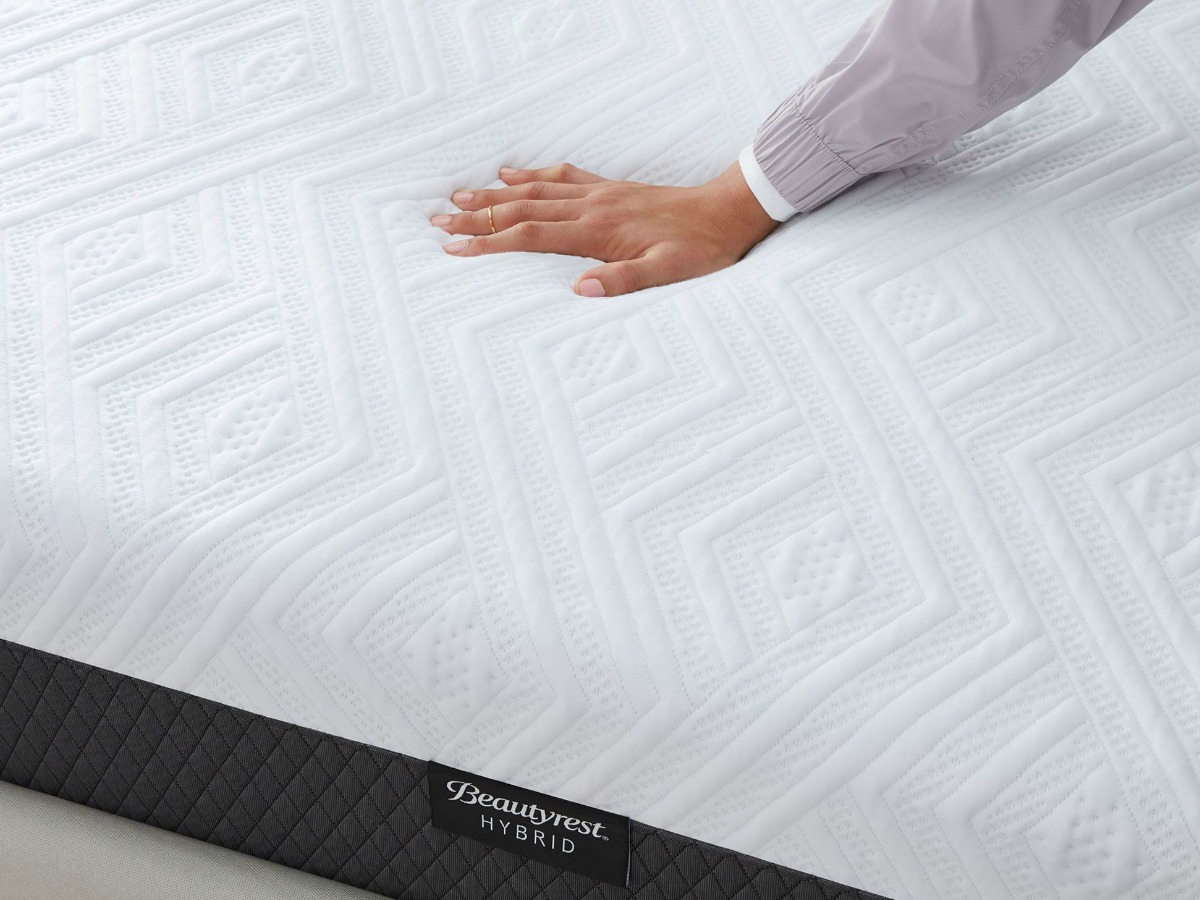 woman pushing on plush mattress