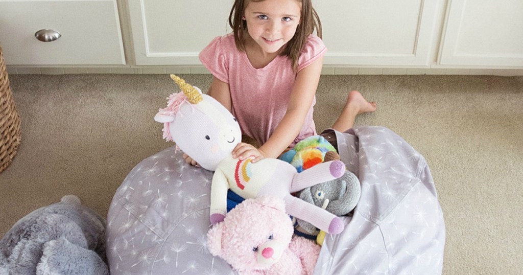 Girl filling her Creative QT Storage Bean Bags with stuffed animals 