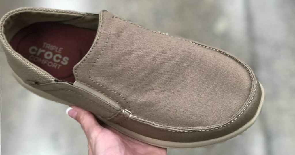 Tan Crocs Mens Slip On Shoes being held 