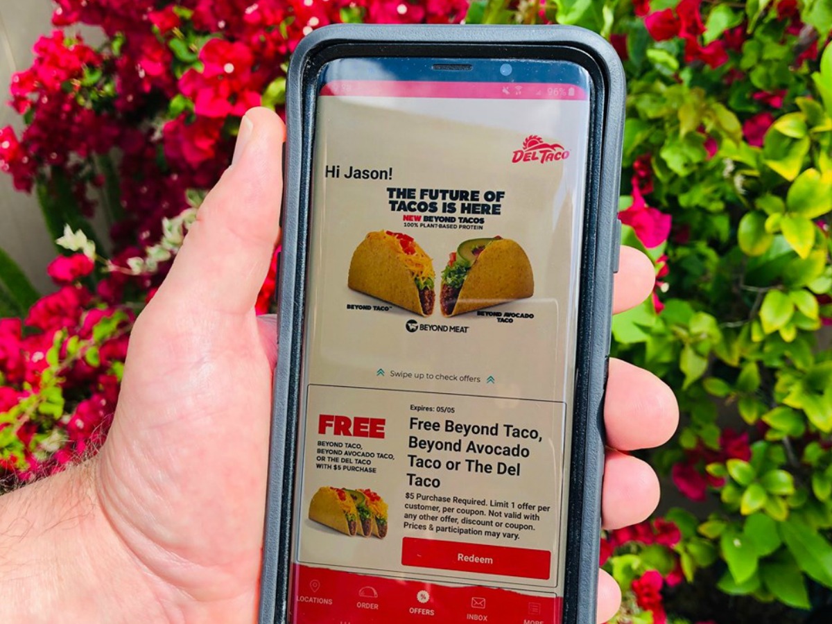 hand holding smartphone showing the del taco app