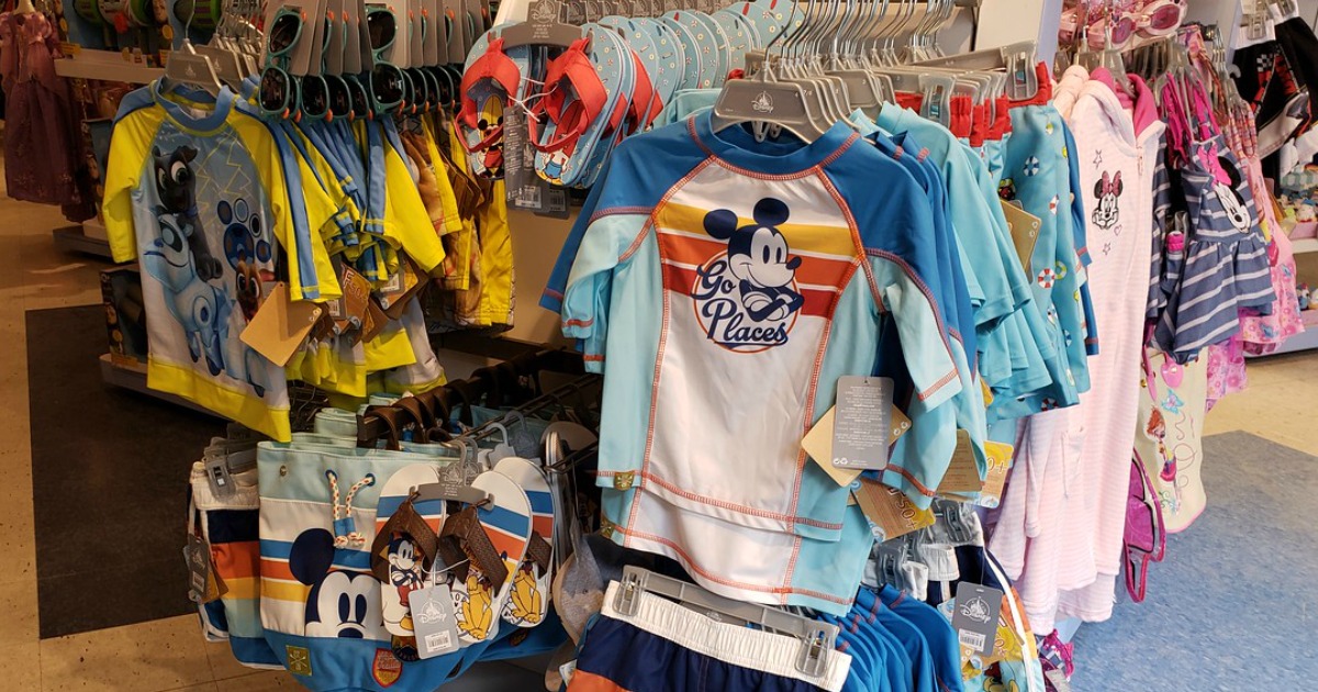 Mickey Mouse Go Places rash guard for kids hanging on rack in-store with various Disney kids swimwear