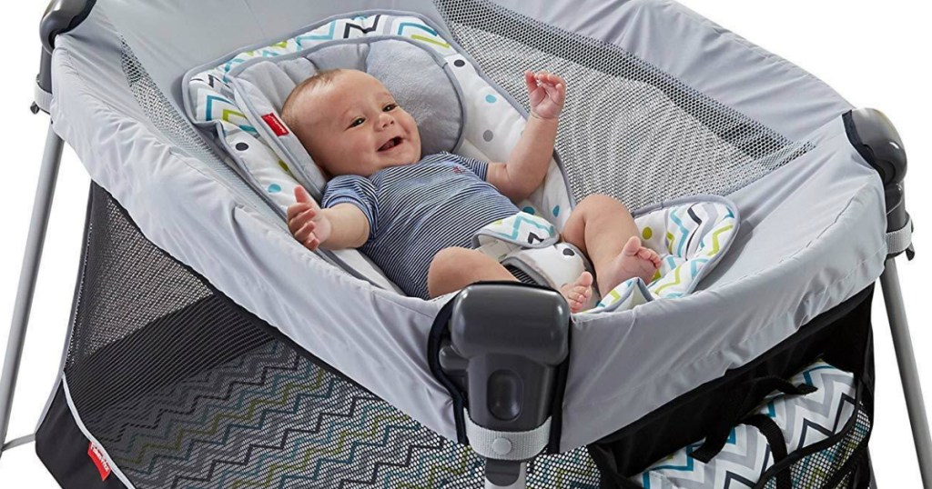 baby smiling laying in play yard