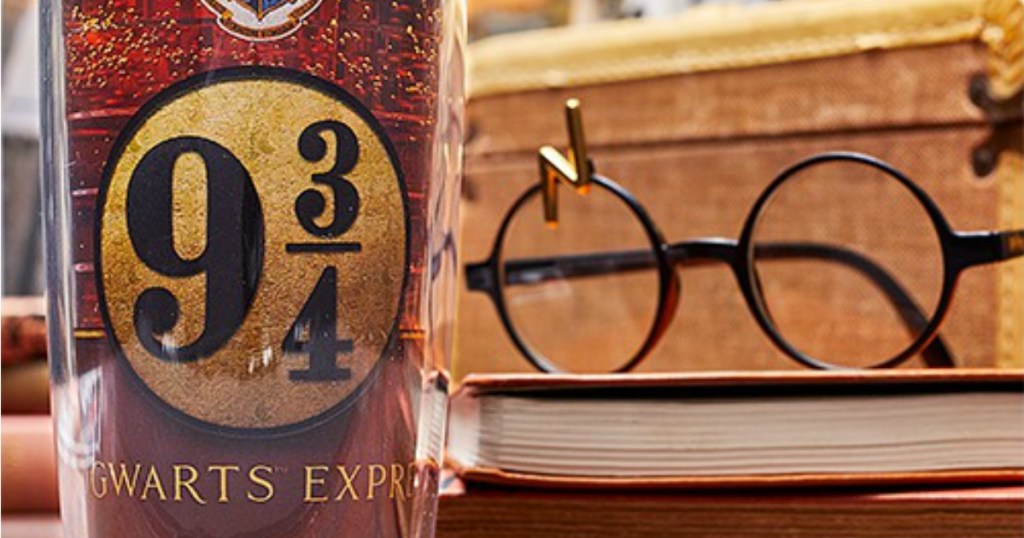 Harry Potter tumbler next to lightning bolt scar glasses on book