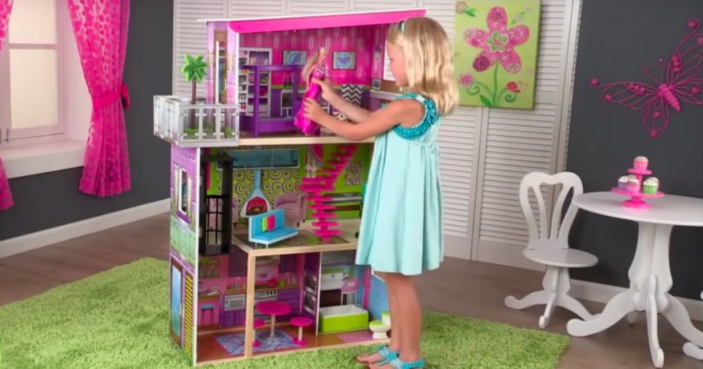 a girl playing with the KidKraft Super Model Dollhouse