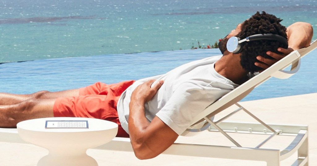 man listening to book on beach with Kindle Unlimited