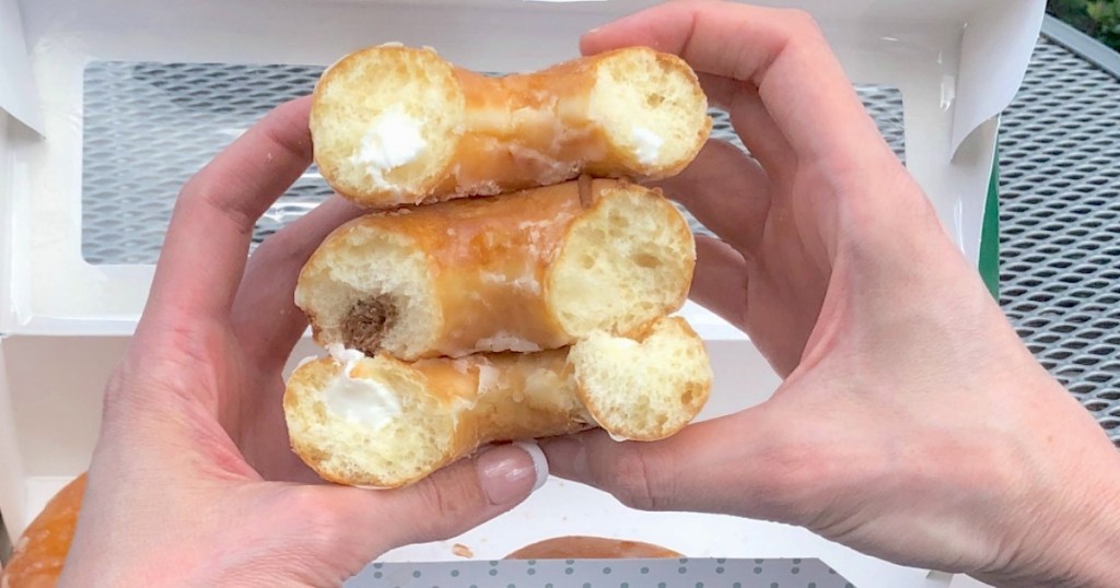 holding 3 Krispy Kreme filled doughnuts 