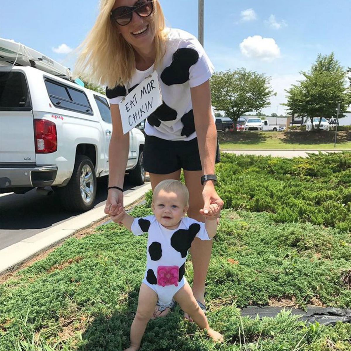 Mom and baby dressed as cows with white shirts covered in black felt spots 
