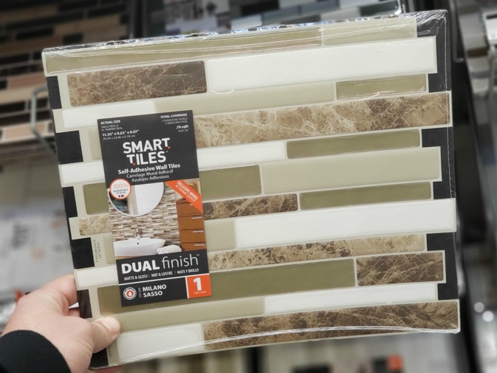 hand holding tile with beige and white at store display