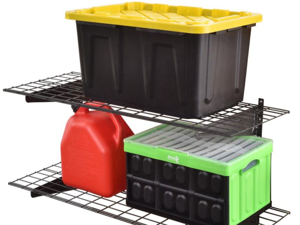 two muscle racks on top of each other with black tote with yellow lid, gas can, and black and green box