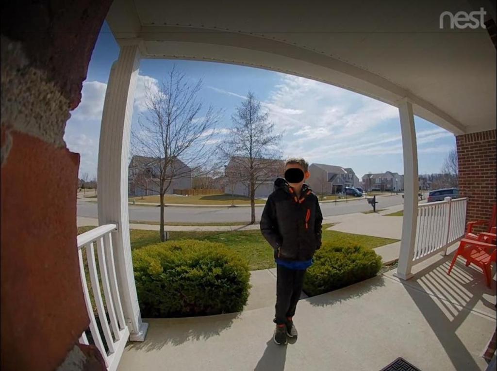 nest doorbell view of kid standing on front porch in neighborhood 