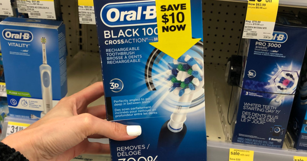 Woman's hand holding Oral-B Pro 1000 rechargeable toothbrush at Walgreens