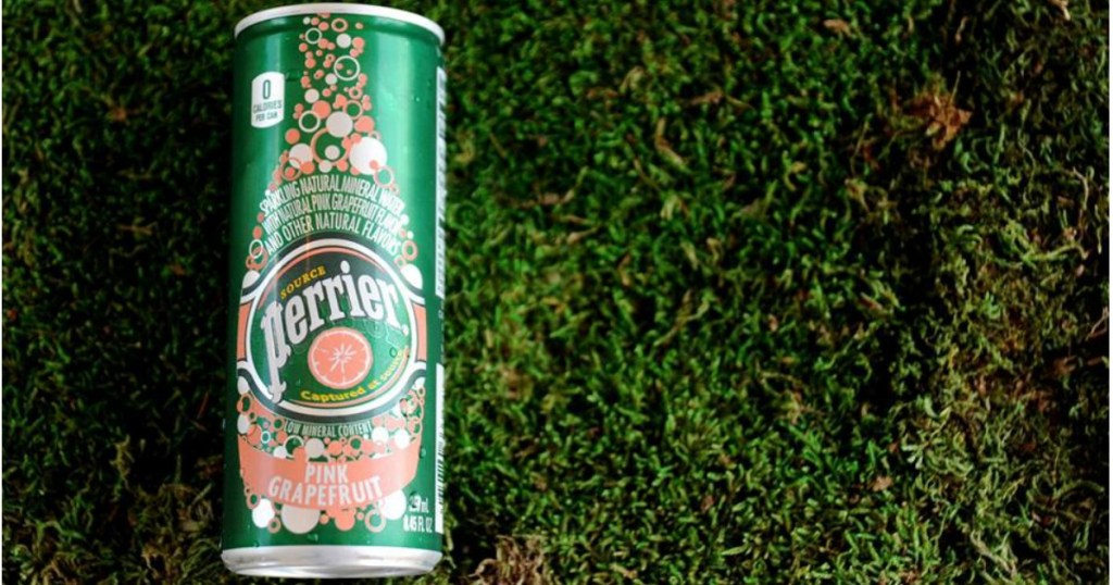 Can of Pink Grapefruit Perrier Flavored Mineral Water laying on grass