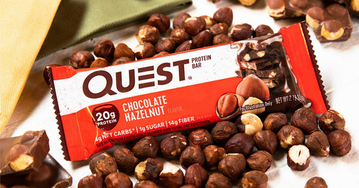 quest protein bar in package laying on top of hazelnuts