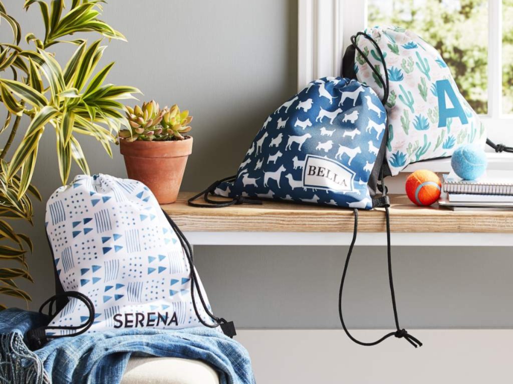 three shutterfly drawstring backpacks in home on windowsill