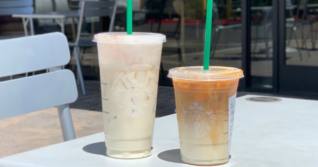 two iced Starbucks beverages sitting outside of Starbucks on a table