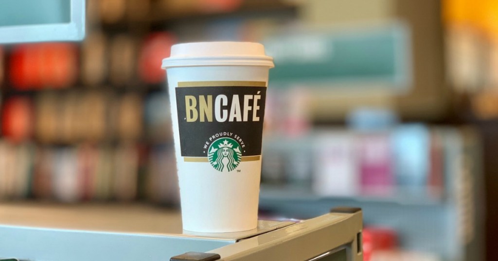 starbucks cup with barnes & noble cafe printing sitting on a bookshelf