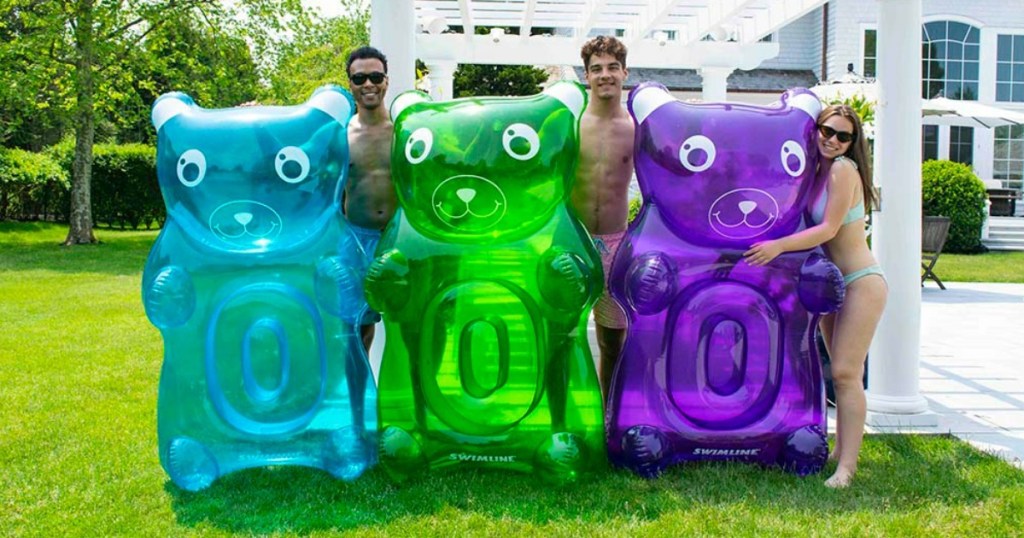 People holding Swimline Gummy Bear Pool Floats 