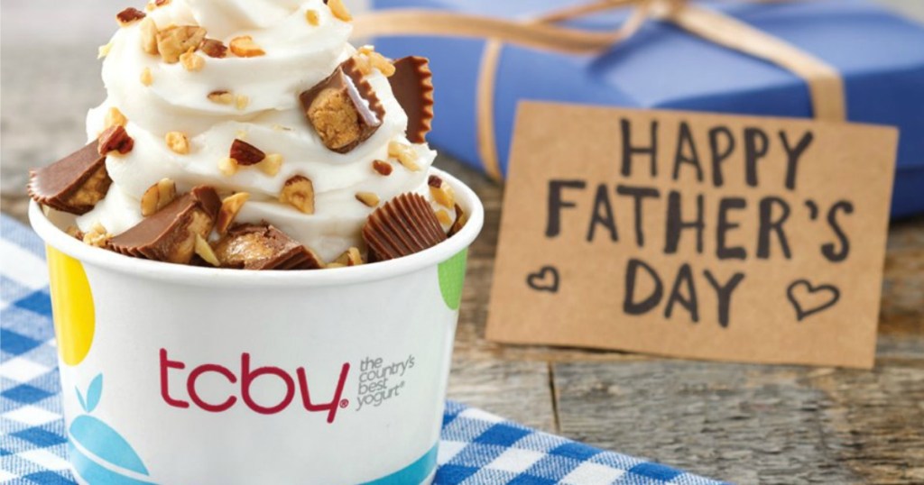 Frozen yogurt topped with Reese's Cups in white cup next to a handwritten Happy Father's Day sign