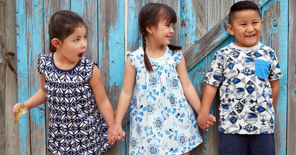 kids holding hands next to barn door