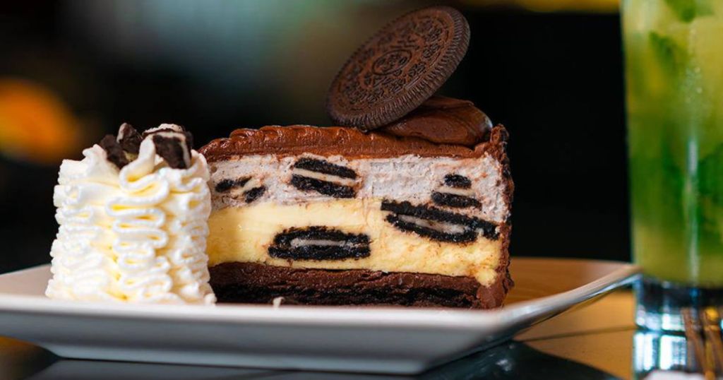 The Cheesecake Factory Oreo Cheesecake on plate with whipped cream and pineapple mojito