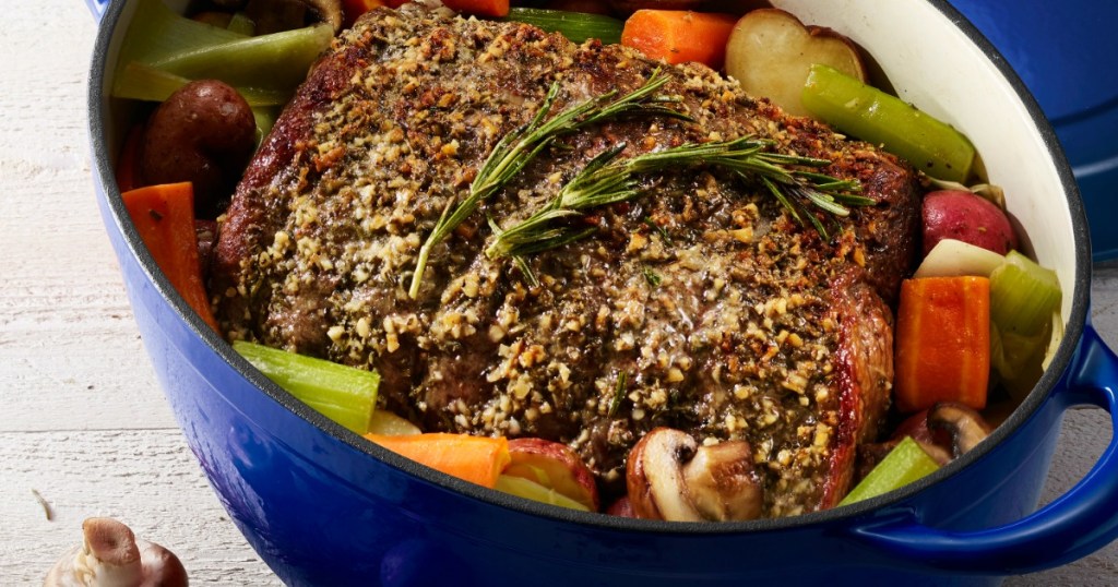 blue dutch oven with meat and vegetables in it