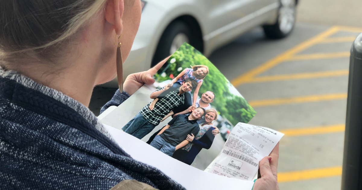 Collin looking at 8x10 photo print featuring her family of 5