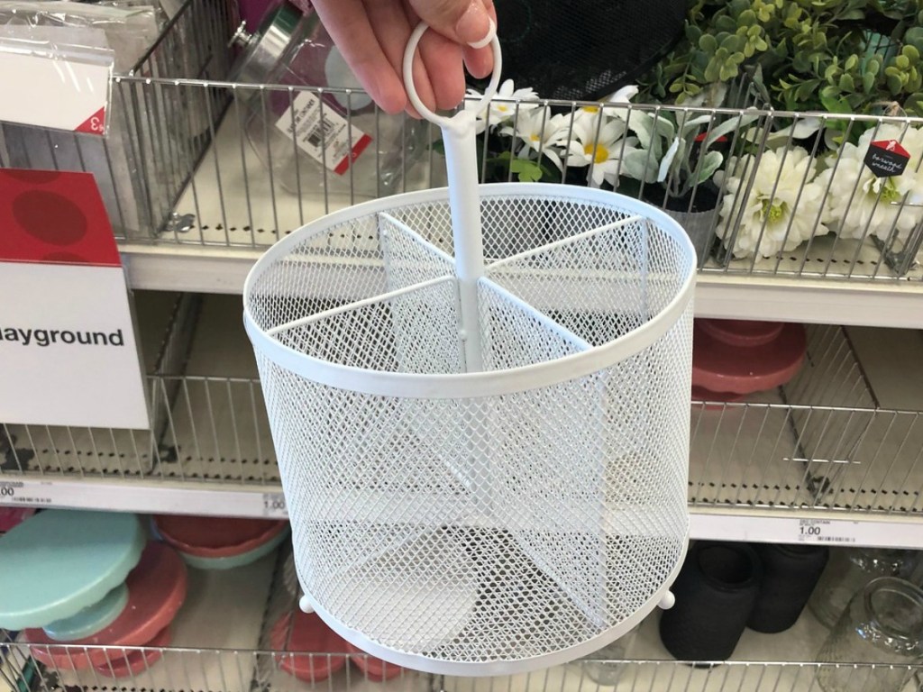 handing holding white caddy for pencils by store display